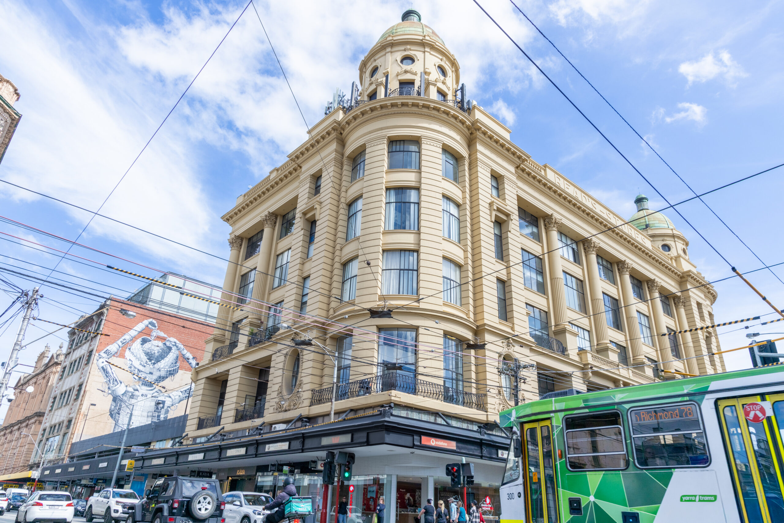 Ornate corner building with green tram