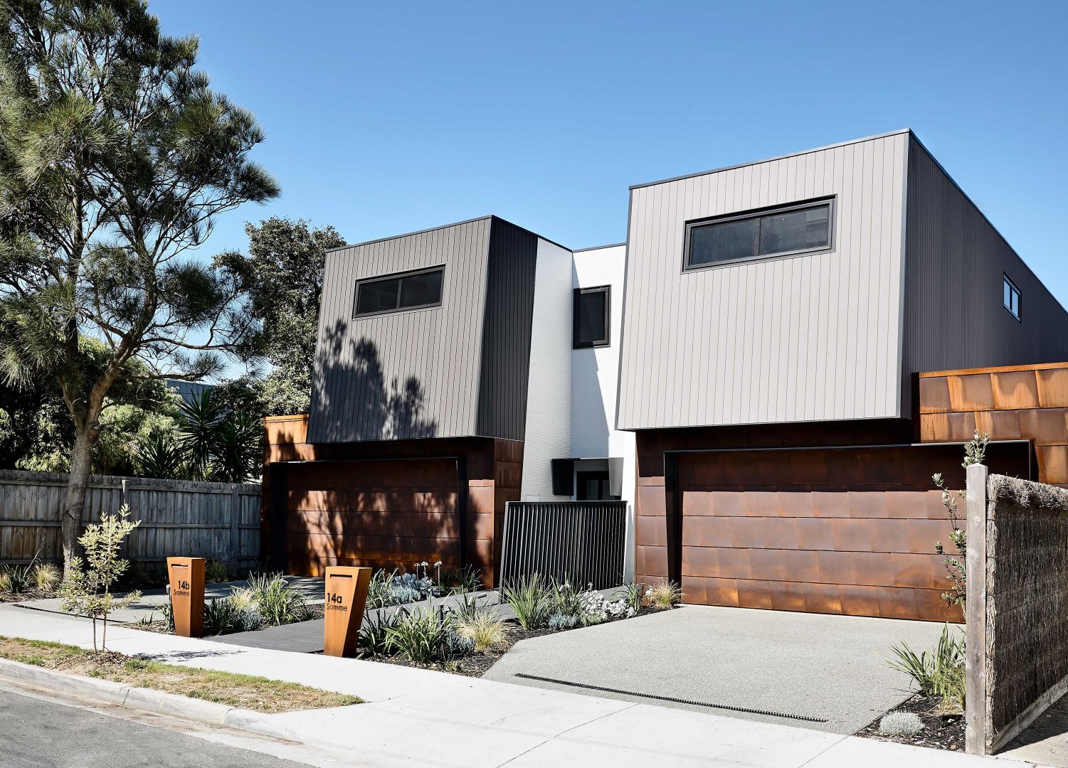 Contemporary duplex with twin garages and landscaping