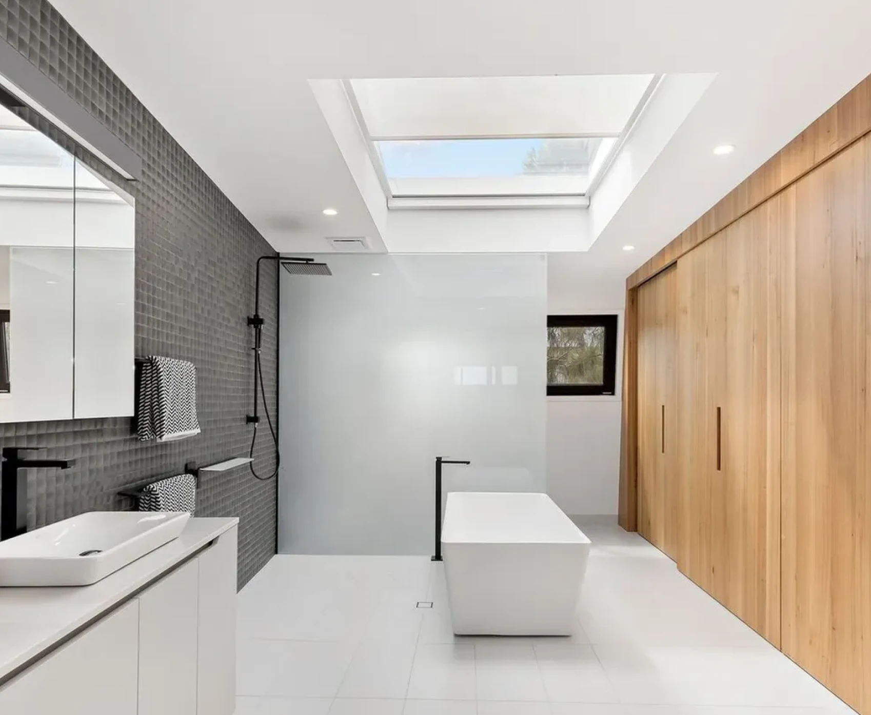 Modern bathroom with freestanding tub and skylight